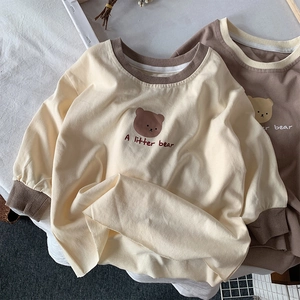 Détail des poignets côtelés et de l'imprimé ours sur le t-shirt à manches longues