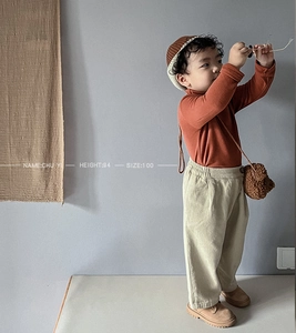 Close-up of caramel high neck sweater and beige corduroy pants with teddy bear bag
