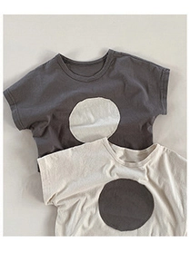 Flat lay of minimalist children's cotton t-shirts with large contrast polka dot prints