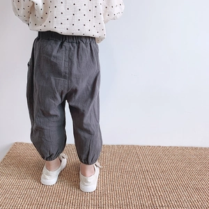 Rear view of loose dark grey kids harem pants with elastic waist and gathered ankles