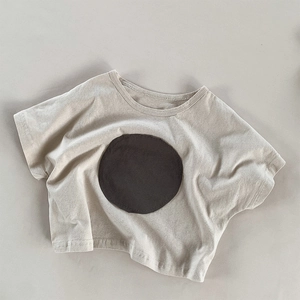 Detail of grey cotton girl's T-shirt with a stylish dark round patch on the front