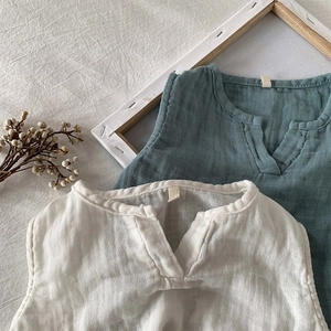 Dettaglio di gilet per bambini in cotone e lino bianco e verde acqua con trama stropicciata