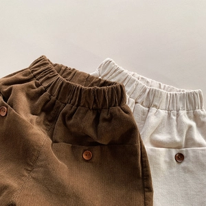 Detail of corduroy texture and decorative buttons on loose toddler casual pants