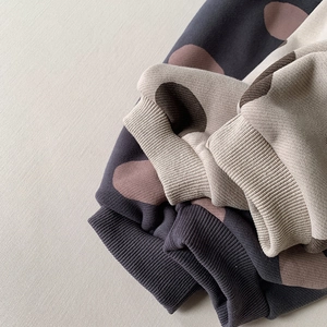 Detailed close-up of ribbed cuffs and contrasting polka dot patterns on kids' thermal pants