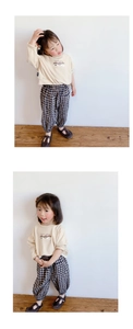 Detalle de camiseta de manga larga con setas y pantalones de cuadros para niña pequeña
