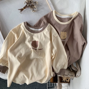 Détail de t-shirts enfants à manches longues en coton avec motif ours et col contrasté