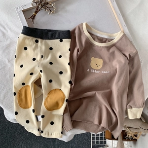 Detail of baby bear sweatshirt and polka dot pants with yellow knee patches