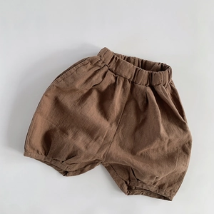 Close-up of brown cotton linen kids shorts with elastic waistband and tapered leg detail