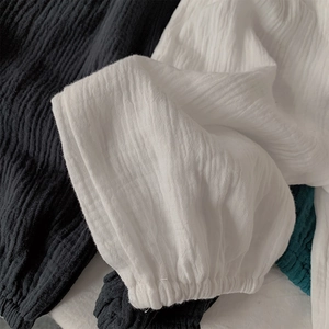Détail du tissu en gaze de coton respirant avec des poignets élastiques sur le pantalon