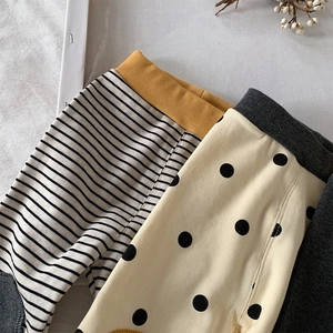Detail of toddler cotton leggings featuring striped and polka dot patterns with elastic waist