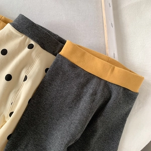 Detail of girls cotton leggings featuring polka dot patterns and ribbed texture details