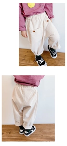 Detail of girls' corduroy trousers featuring elastic waist and wood style buttons