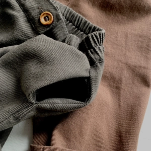 Kids loose cotton twill pants with elastic waist and wood-tone button details