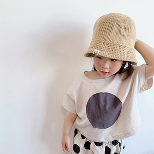 Close-up of a lightweight woven straw bucket hat with a round smiley face patch for kids