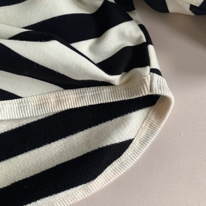 Macro view of black and white striped cotton knit fabric with ribbed hem detail