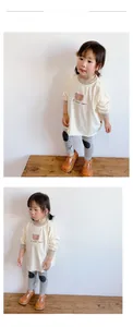 Détail de haut en coton pour fille avec motif ours et pantalon à rayures noires