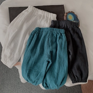 Détail de pantalons légers en gaze de coton pour enfants en blanc, sarcelle et gris