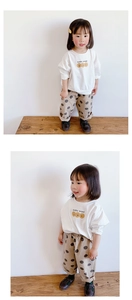 Detalle de camiseta blanca de manga larga para niña con estampado y pantalones de lunares