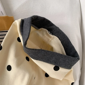 Detail of children's polka dot leggings showing elastic waistband and stitching