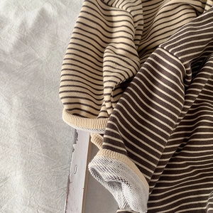 Detail shot of striped long sleeve cotton shirt showing waffle texture and rolled cuff edge