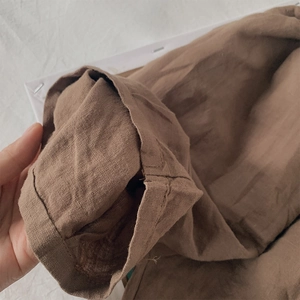 Detailed macro view of the natural linen texture and brown fabric hem of kids pants