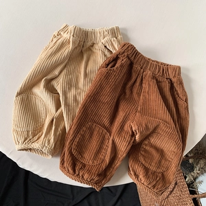 Detailed flat lay of beige and brown corduroy trousers for kids with elastic cuffs