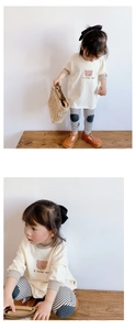 Détail d'un sweat-shirt beige pour fille avec ours et legging rayé assorti