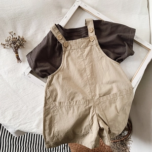 Flat lay of cotton linen toddler overall set with wood buttons and dark brown t-shirt