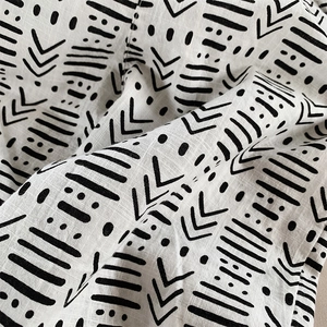 Close-up of kids cotton linen fabric with black and white ethnic geometric patterns