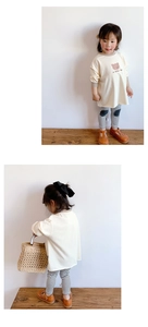 Détail du t-shirt manches longues ours et leggings rayés avec empiècements aux genoux
