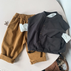 Flat lay of cotton kids vest and trousers set with fabric details and neutral aesthetic