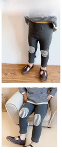 Detail of dark grey girls leggings featuring black and white striped knee patches