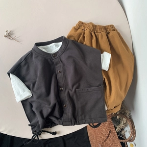 Flat lay of vintage kids outfit featuring charcoal vest and ginger loose casual pants