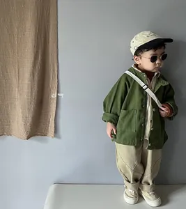 Detailed view of kids olive green cotton canvas jacket featuring utility cargo pockets