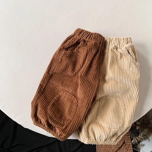 Detail of corduroy kids trousers in brown and beige with elastic waist and knee patches