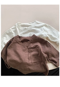 Detail of white and tan cotton long-sleeve kids' shirts with chest pockets