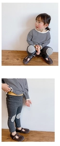 Detail of baby girl stripe leggings with round knee patches and vintage brown shoes