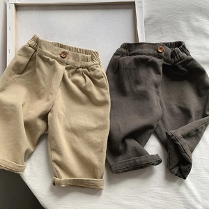 Detail of high-density cotton twill trousers for kids in beige and dark brown colors
