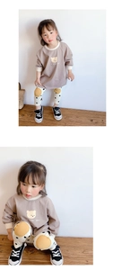 Détail d'un sweat-shirt en coton avec motif ours et leggings à pois pour filles