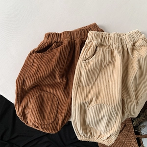 Detailed flat lay of children's corduroy trousers in brown and beige with knee patches