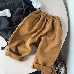 Close-up of ginger cotton kids pants with elastic waist and stylish rolled cuffs