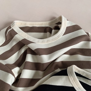 Macro detail of the ribbed round neckline and soft striped knit fabric of the children shirt