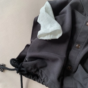 Deep grey kids cotton vest with wooden buttons and contrasting white cuffs