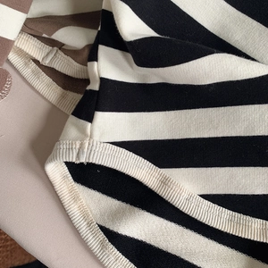 Close-up of black and white striped cotton fabric with ribbed cuff detail and flat stitching
