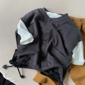 Kids grey knitted vest with buttons and drawstring over white shirt and mustard pants