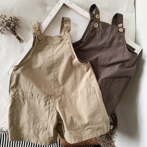 Flat lay of cotton kids overalls in khaki and coffee brown with wooden buttons