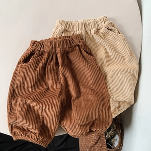 Detail of girls' corduroy trousers in brown and beige with elastic waist and knee patches