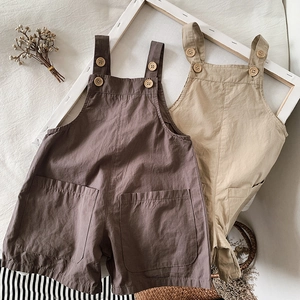 Close-up of breathable cotton linen kids overalls with wooden buttons and large pockets