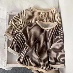 Detail of soft striped knit cotton t-shirts showing round neckline and size 90 label