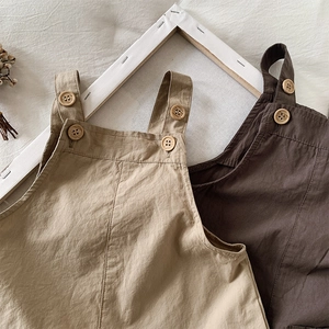 Detail of cotton linen overalls with vintage wooden buttons and breathable texture